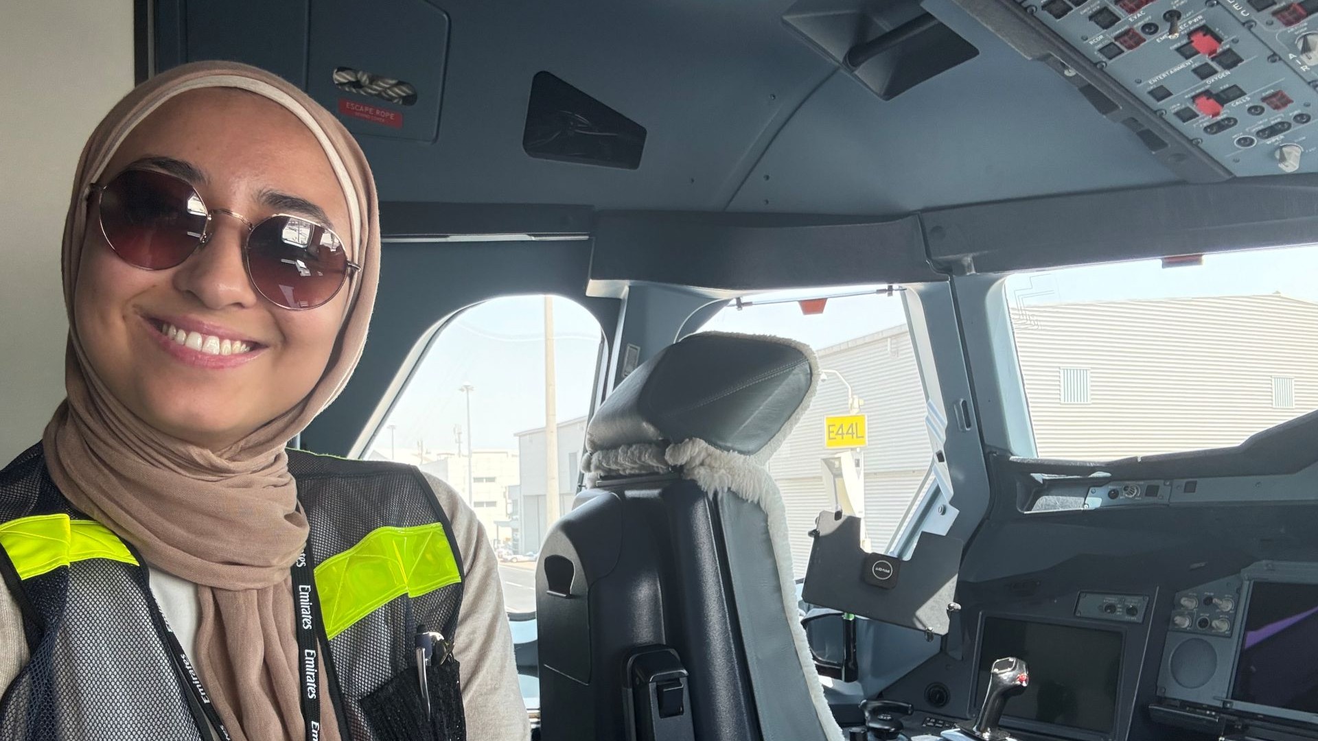 Woman in a hijab taking a selfie in an airplane cockpit